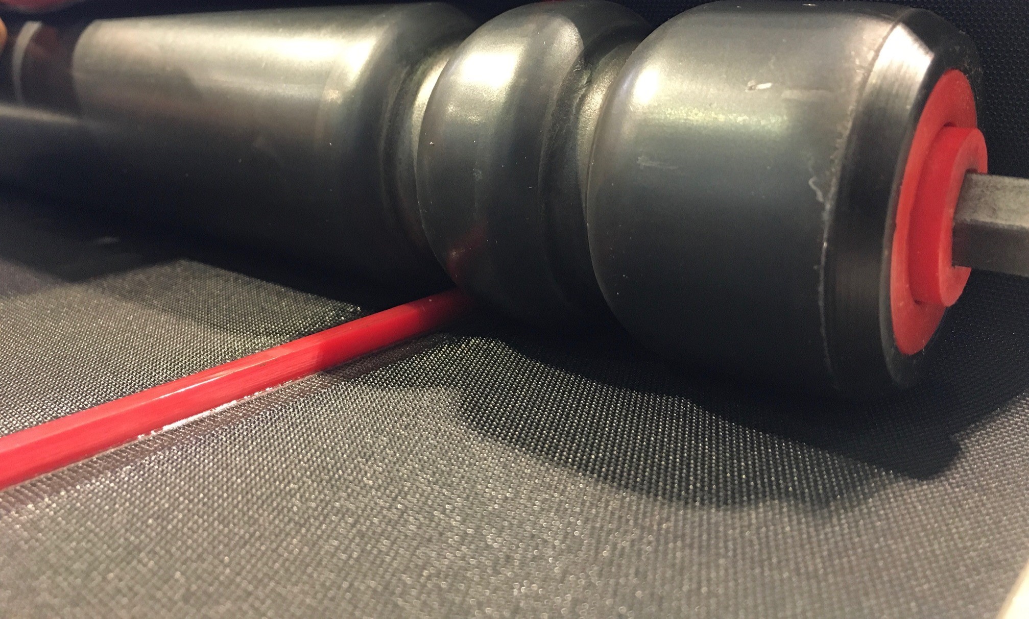 Elastic conveyor belt with roller guide